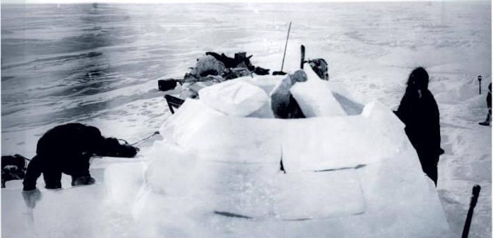 Inuit people building a igloo in the arctic