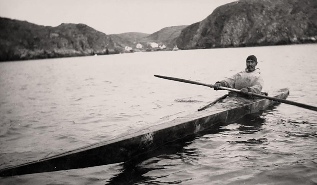 Homme inuit sur un lac dans le premier kayak