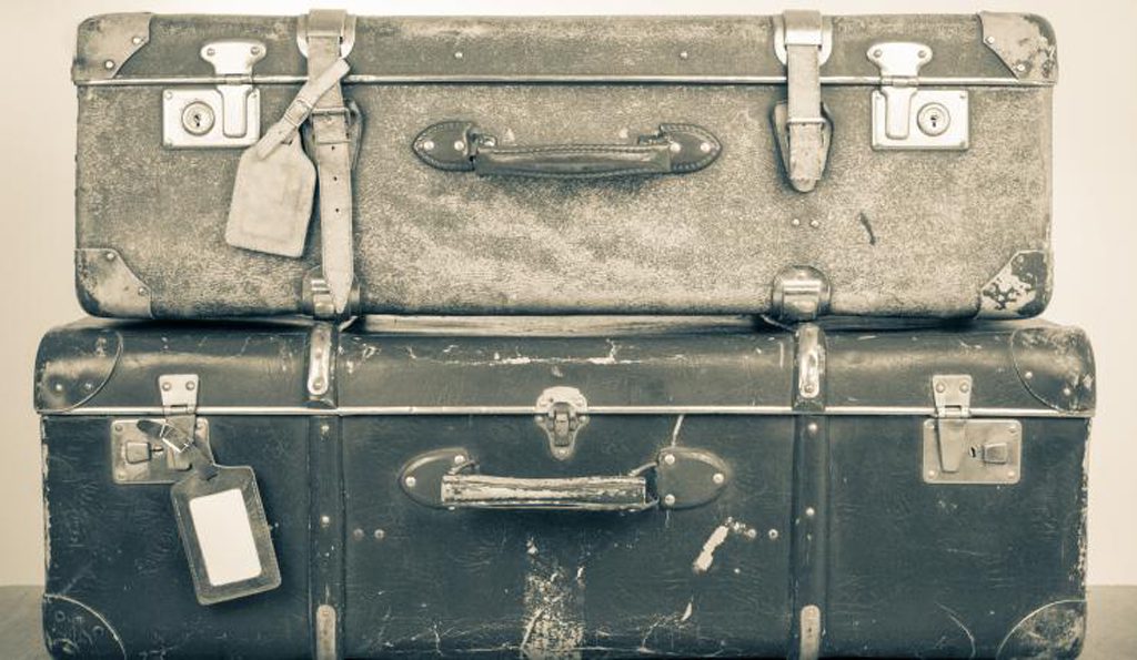 Black and white image of two old suitcases stacked on top of each other