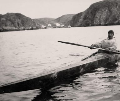 Inuit man on a lake in  the first kayak