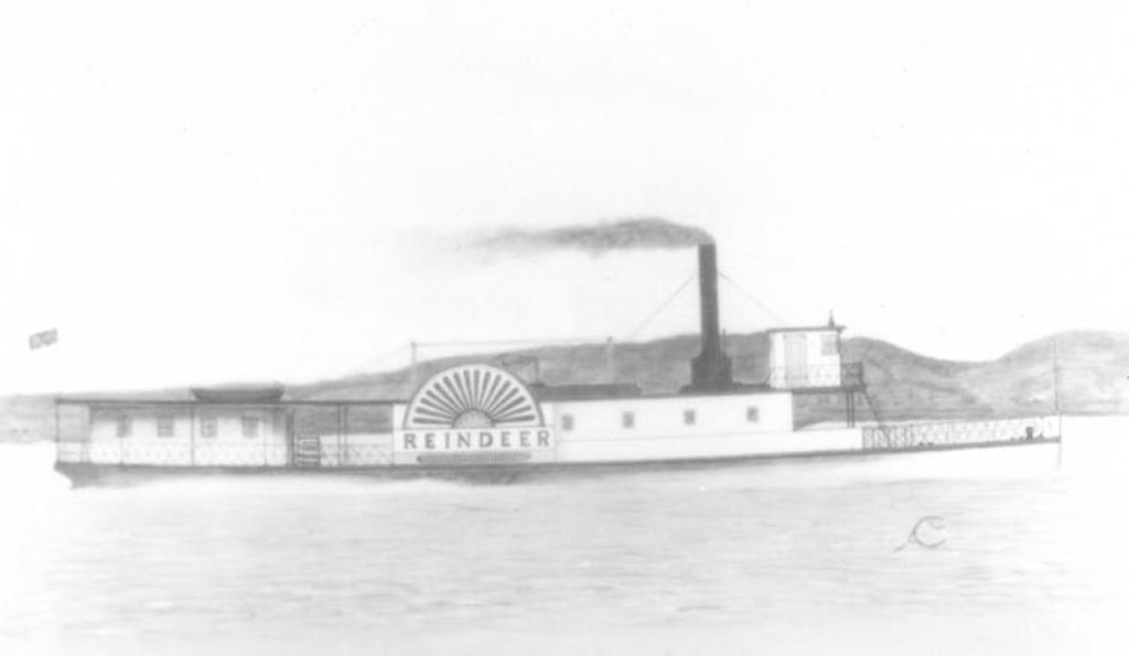 Old black and white image of a steamboat cruising down a river