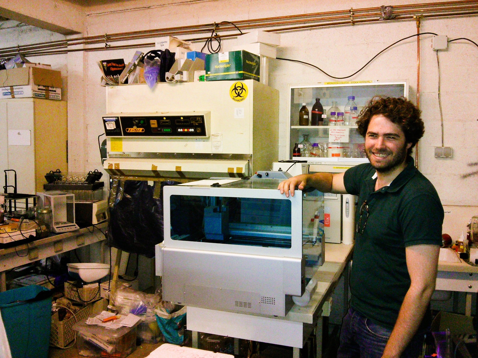 Homme debout devant une machine dans un laboratoire