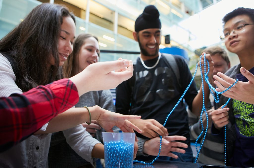 Group of high school kids using a string of beads