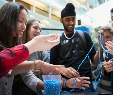 Group of high school kids using a string of beads