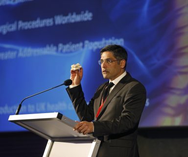 Man speaking on stage behind a podium