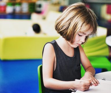 A child writing onto a paper