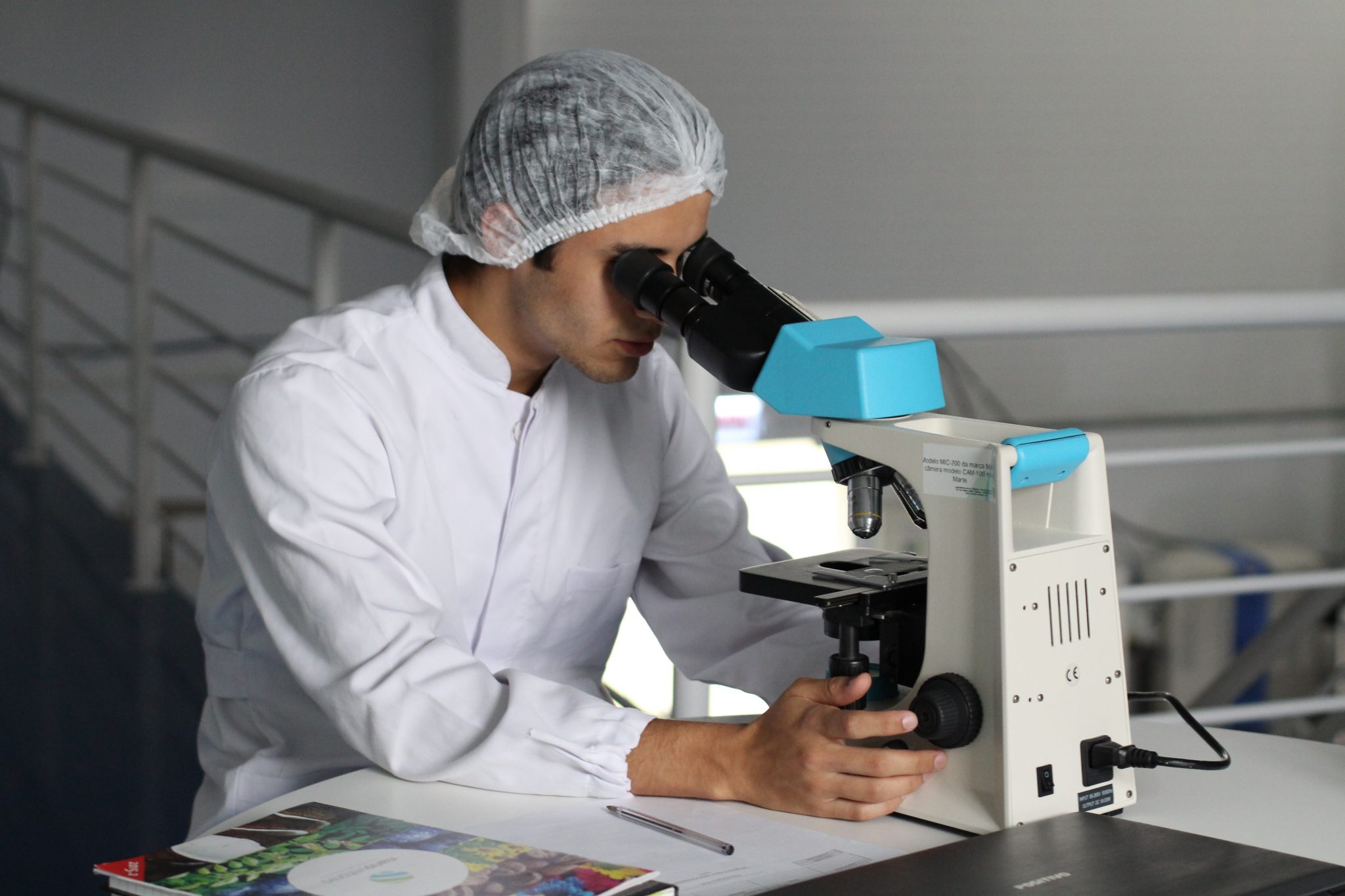 lucas-vasques-9vnACvX2748-unsplash Lab tech looking into a microscope
