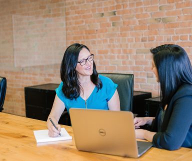 two women chatting at computer by amy hirschi