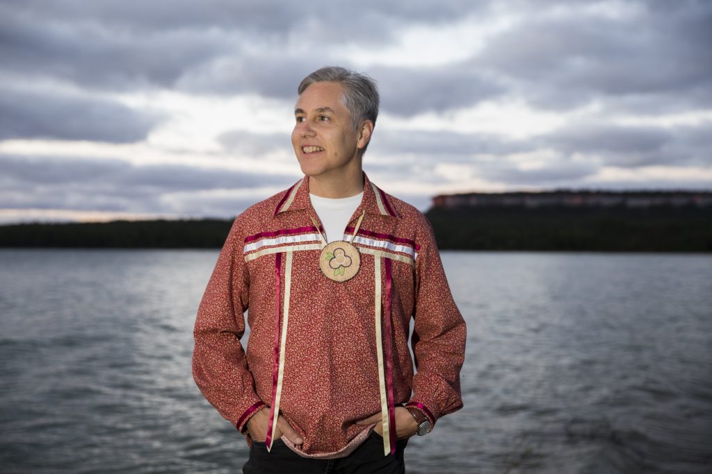 man standing in front of a lake