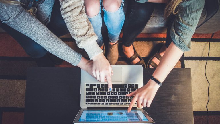Three Girls sitting at a computer pointing to the screen