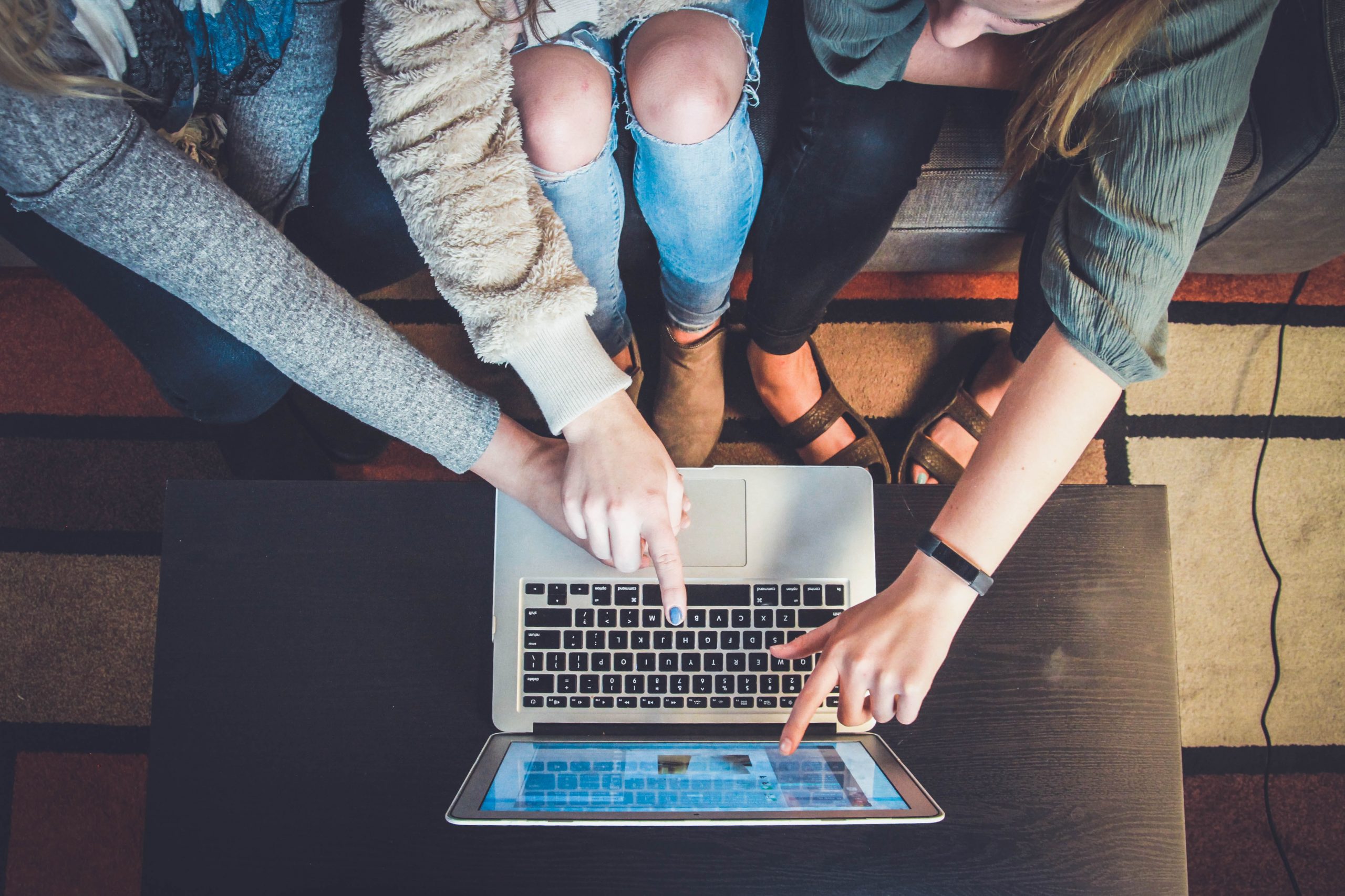 Three Girls sitting at a computer pointing to the screen