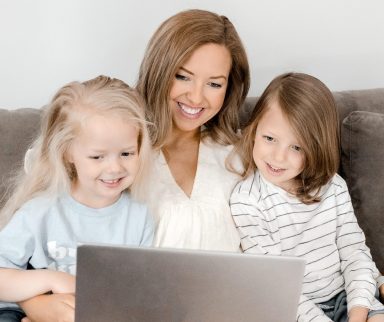 mother and two girls on laptop