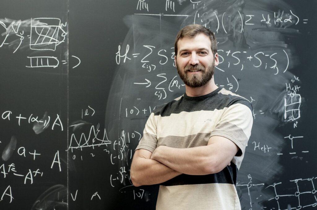 Un homme debout devant un tableau d'équations
