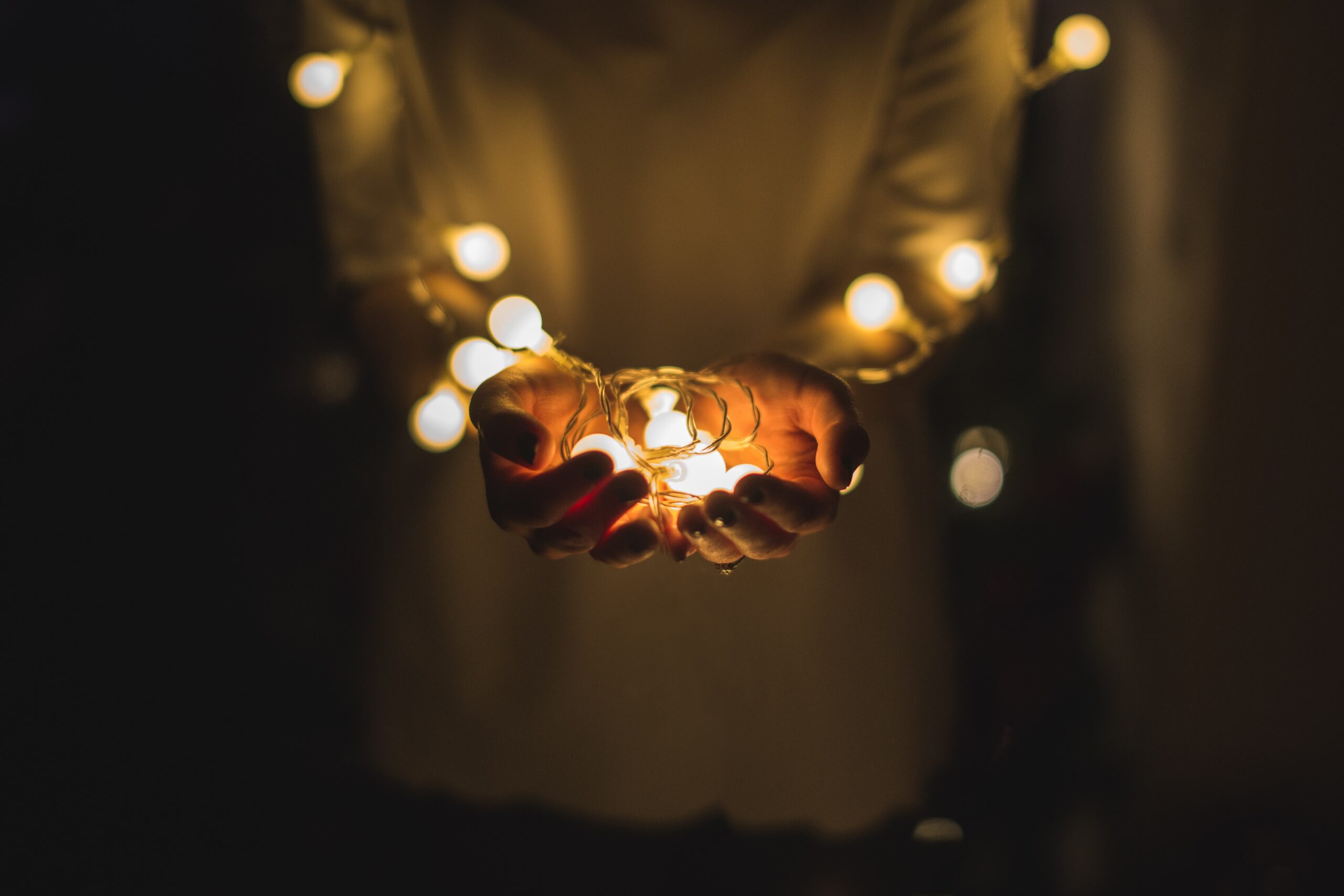 Person holding a string of lights